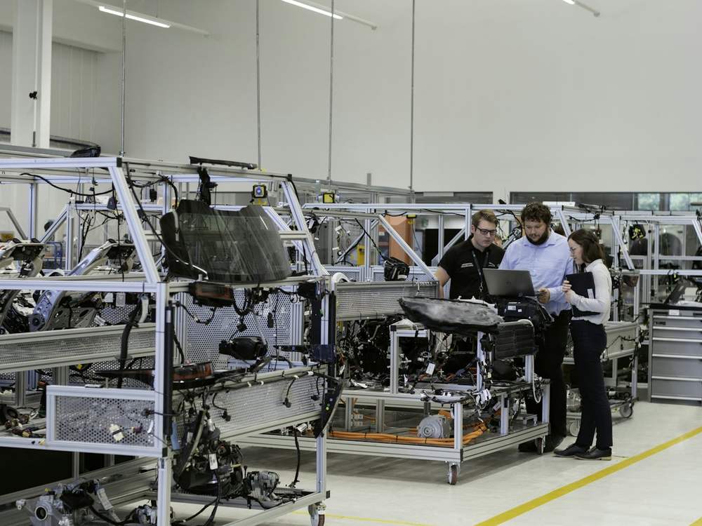 Engineers reviewing test results together on a bright manufacturing floor