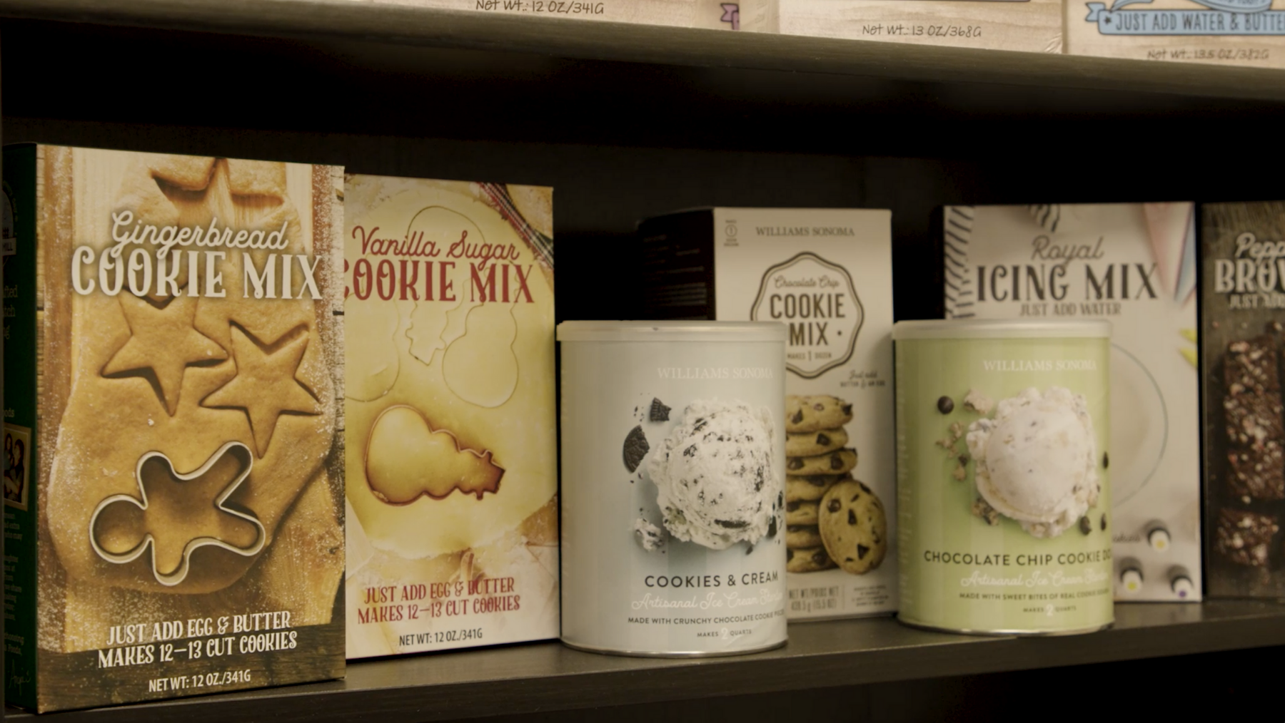 Assortment of boxed baking mixes on a shelf for cookies and icing mix.