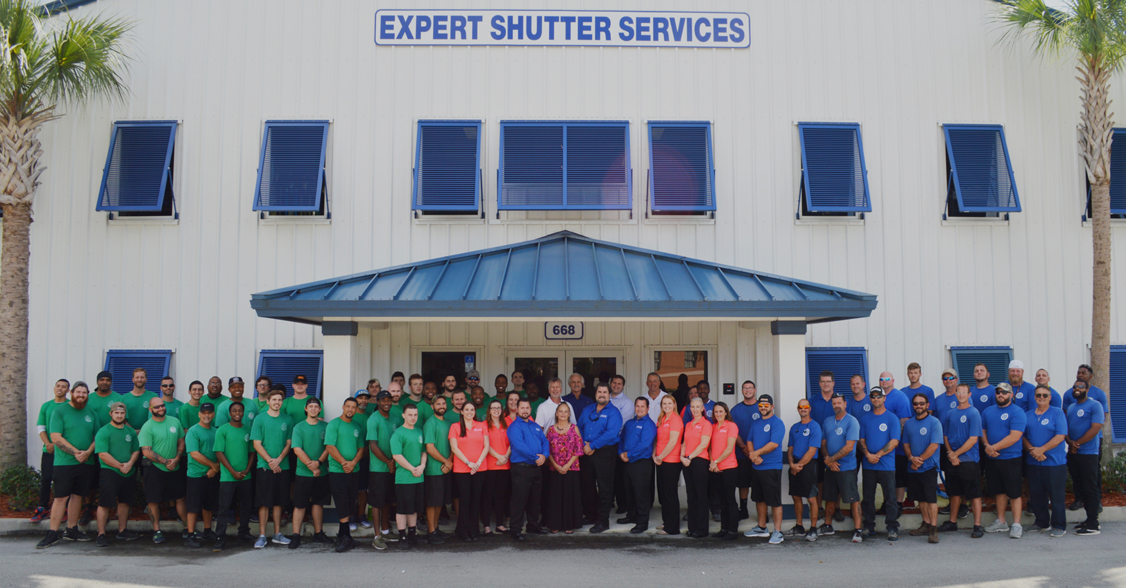 Employees lined up outside of Expert Shutter Service building.