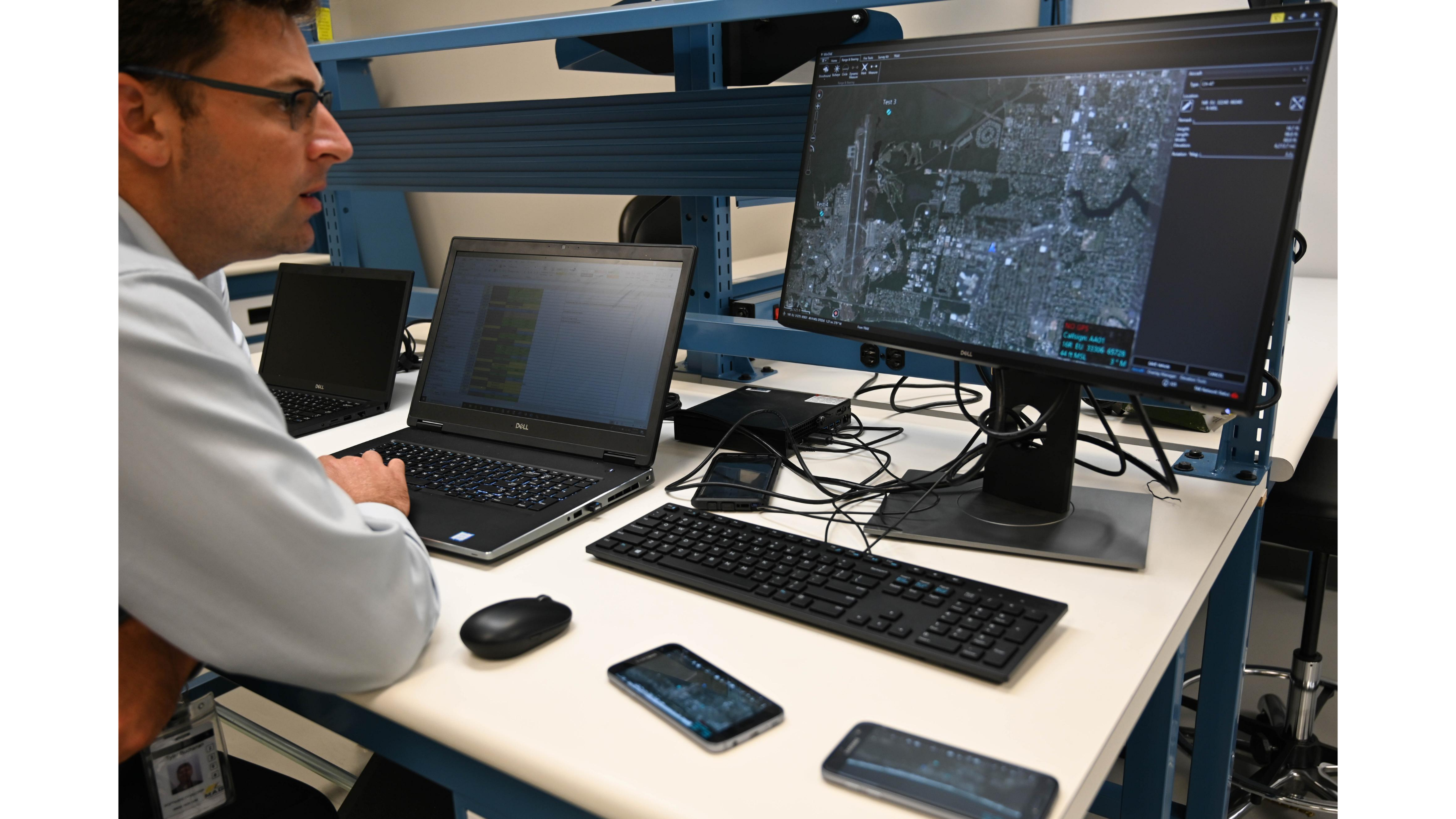 Man working at computer, looking at satellite imaging.