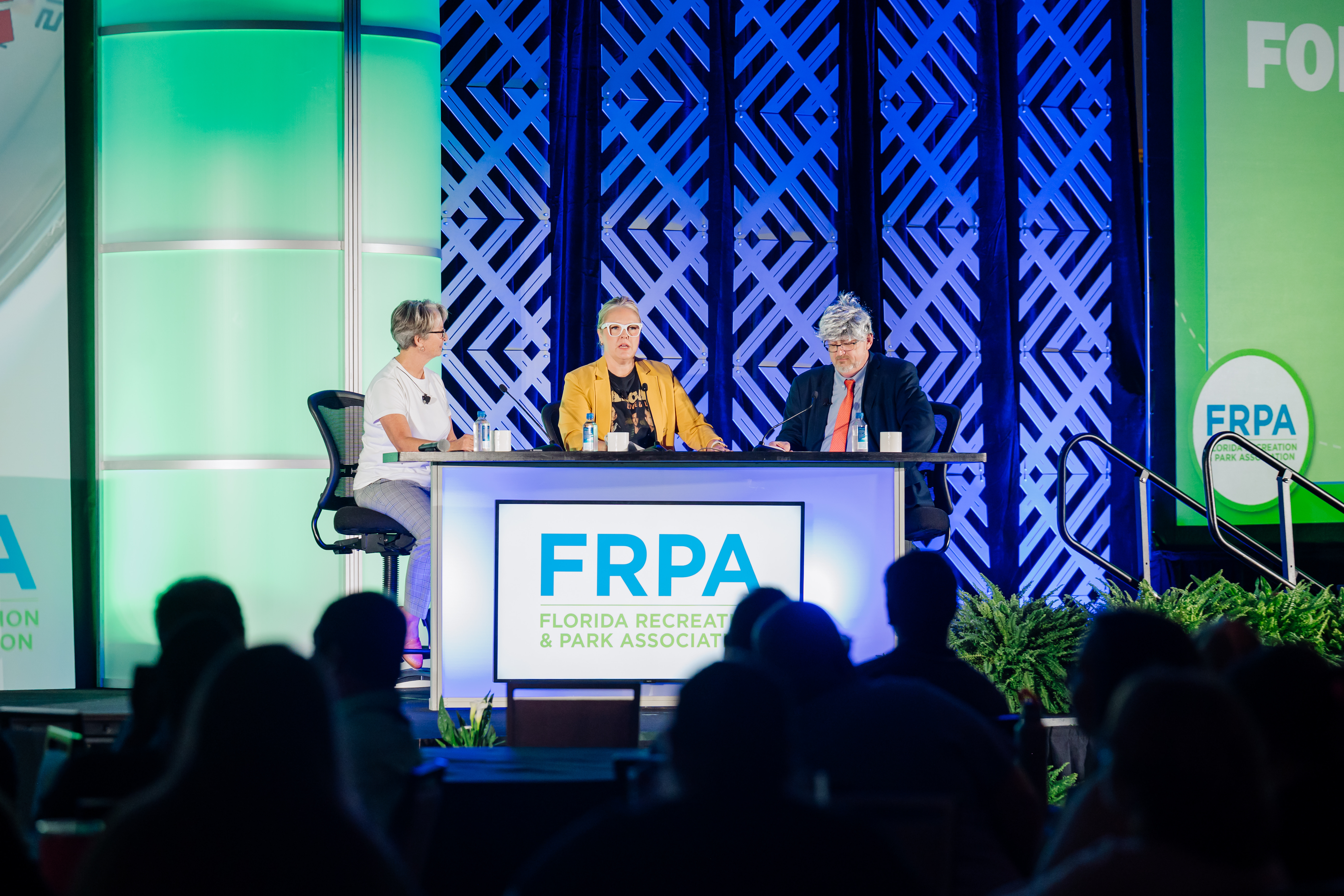 stage with chairs on it - greenery around - from 2023 conference setting