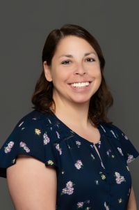 white female, brown hair, smiling, flowers on shirt