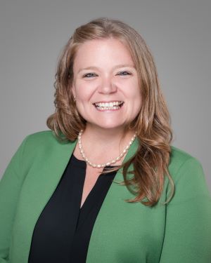 woman blond hair green jacket light skin