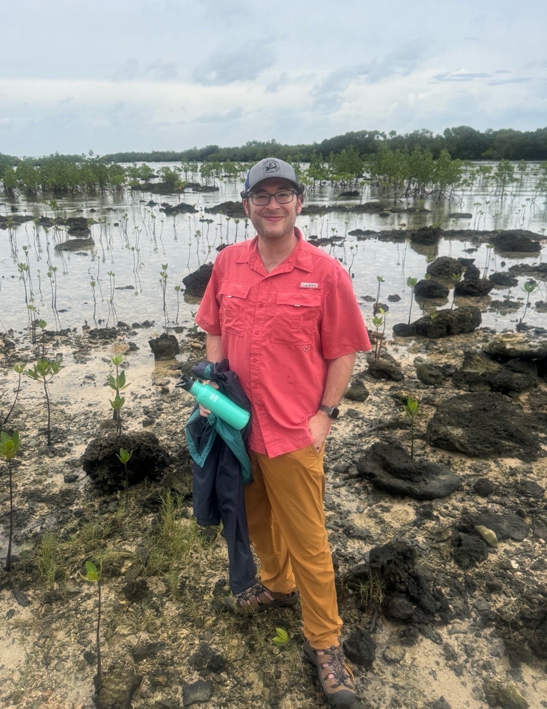 Smiling man standing in shallow coastal water