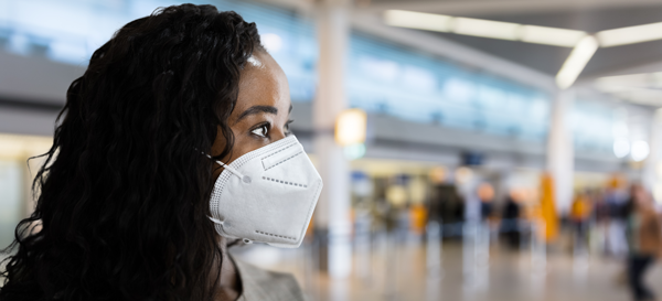 Black woman wearing a face mask in an airport