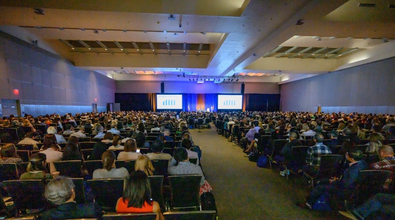 Conference attendees viewing a speaker presentation
