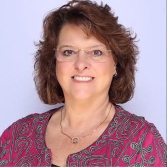 A person wearing glasses and a pink shirtAI-generated content may be incorrect.