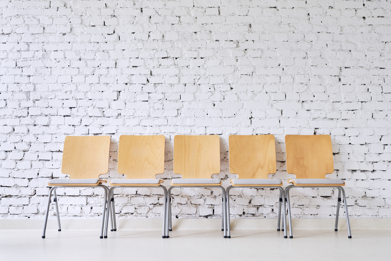 Row-of-five-empty-modern-chairs-in-front-of-stylish-brick-wall-888759586_1257x838.jpeg