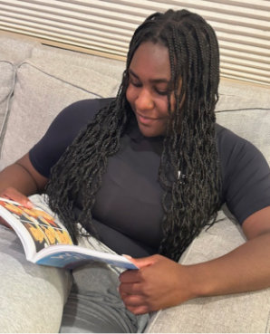 A person reading a book on a couch

Description automatically generated