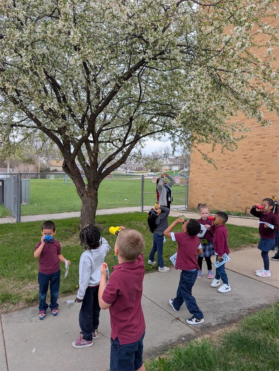 PreK students went outside with bird watching books, binoculars, and view finders to look for birds and worms.