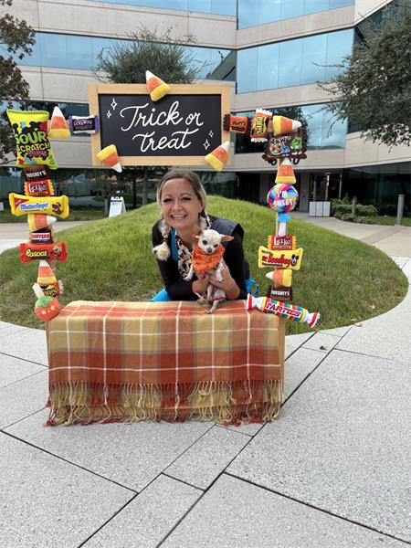 Amber Eby holding senior tan Chihuahua Dolly Rott'n at Halloween themed dog event.