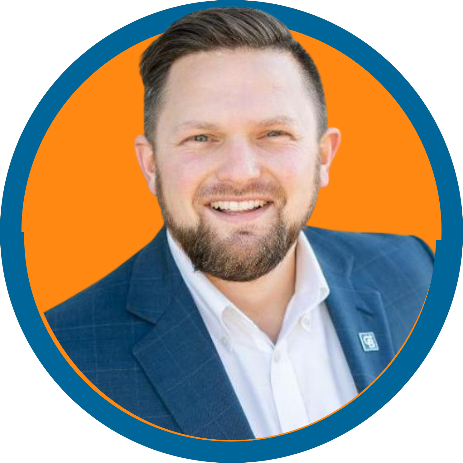 Image of a white man with brown hair and a beard wearing a navy suit jacket