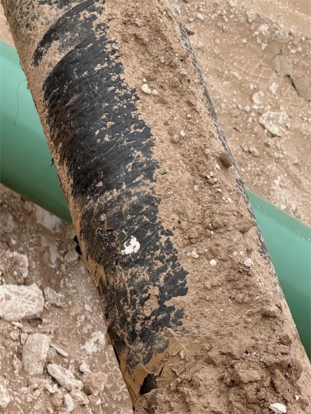 Previously buried exposed cold wrapped pipeline. 