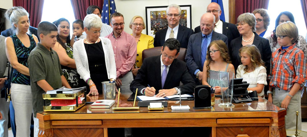 Governor Malloy signs the Connecticut School Nurse Advisory Council Bill 2015 with ASNC members at his side.