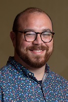 Headshot Andrew Monroe Headshot Andrew Monroe wearing glasses and collared shirt with a pattern