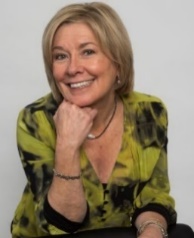 A person smiling with her hand on her chin

Description automatically generated