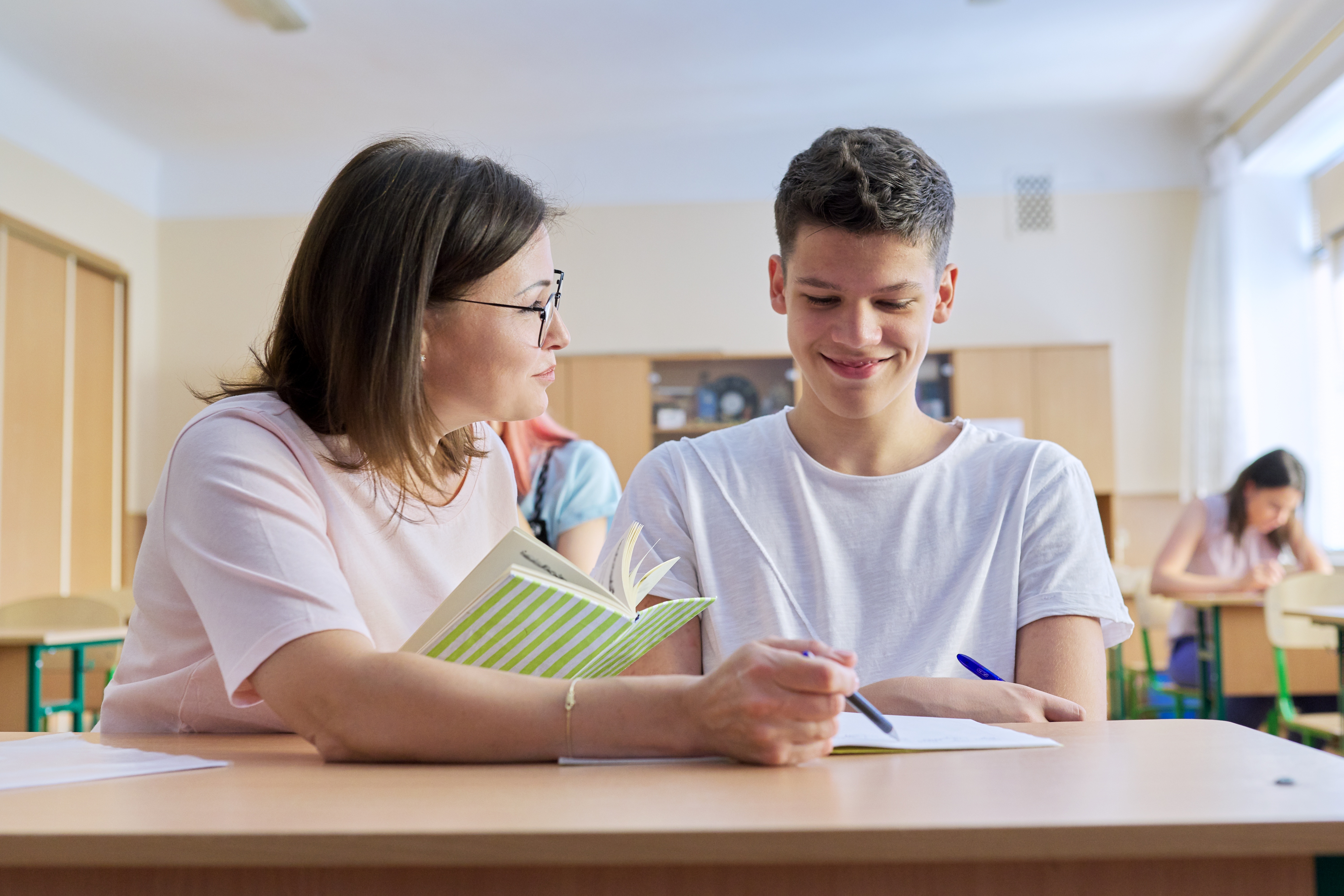 A teacher works with a student in the classroom
