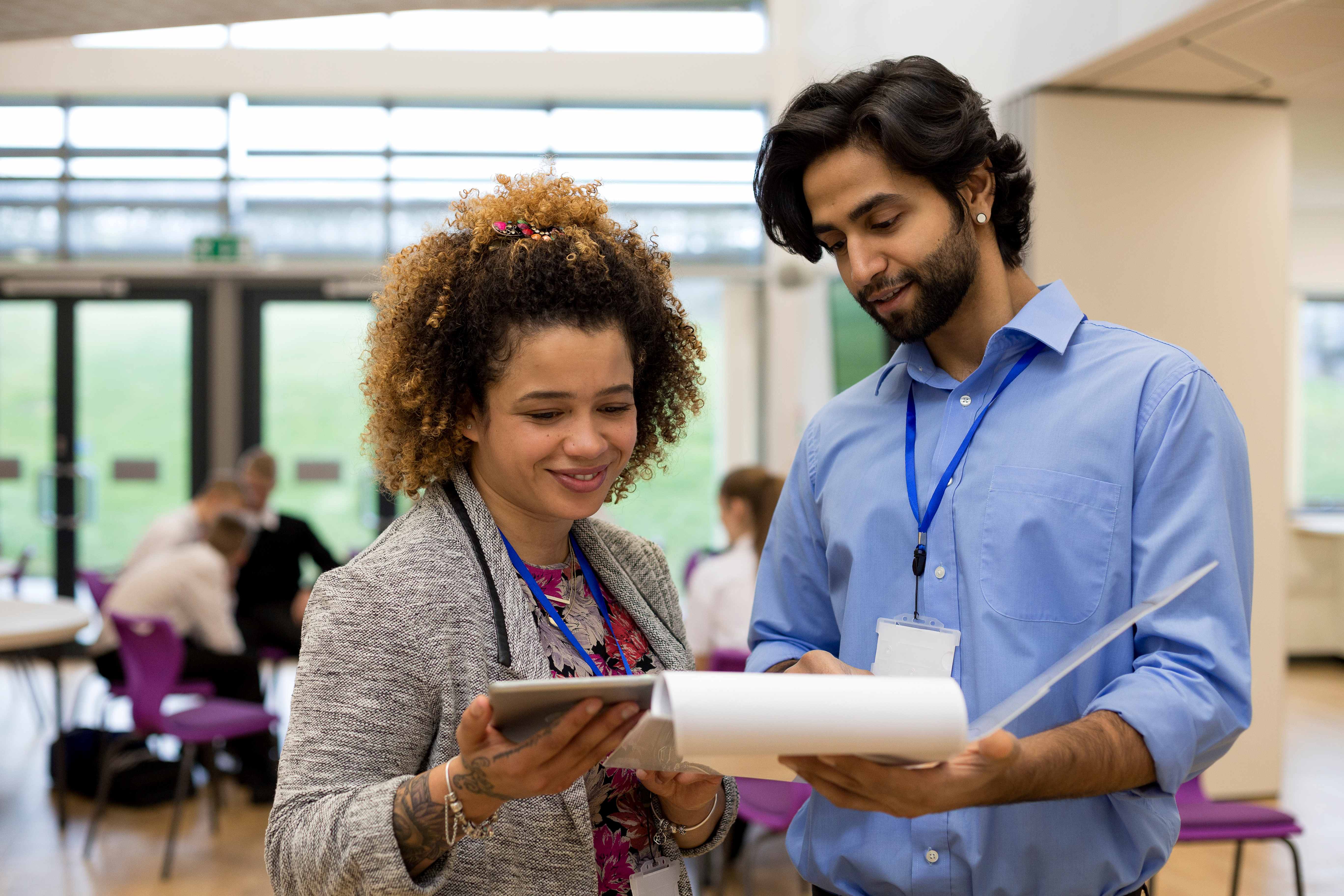 A female and a male teacher talk in a hallway