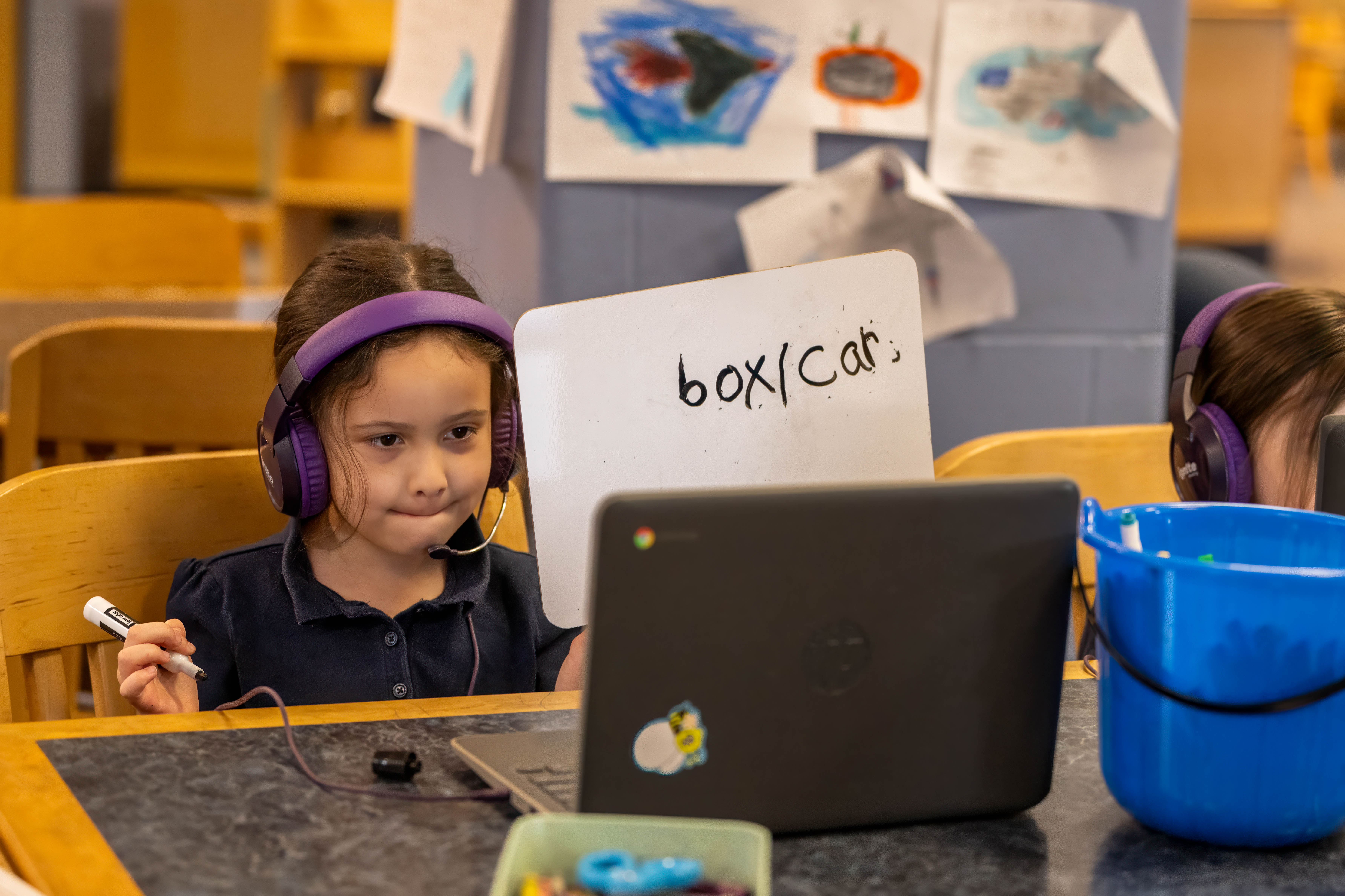 A young girl sits in front of a computer screen doing a reading assignment. 
