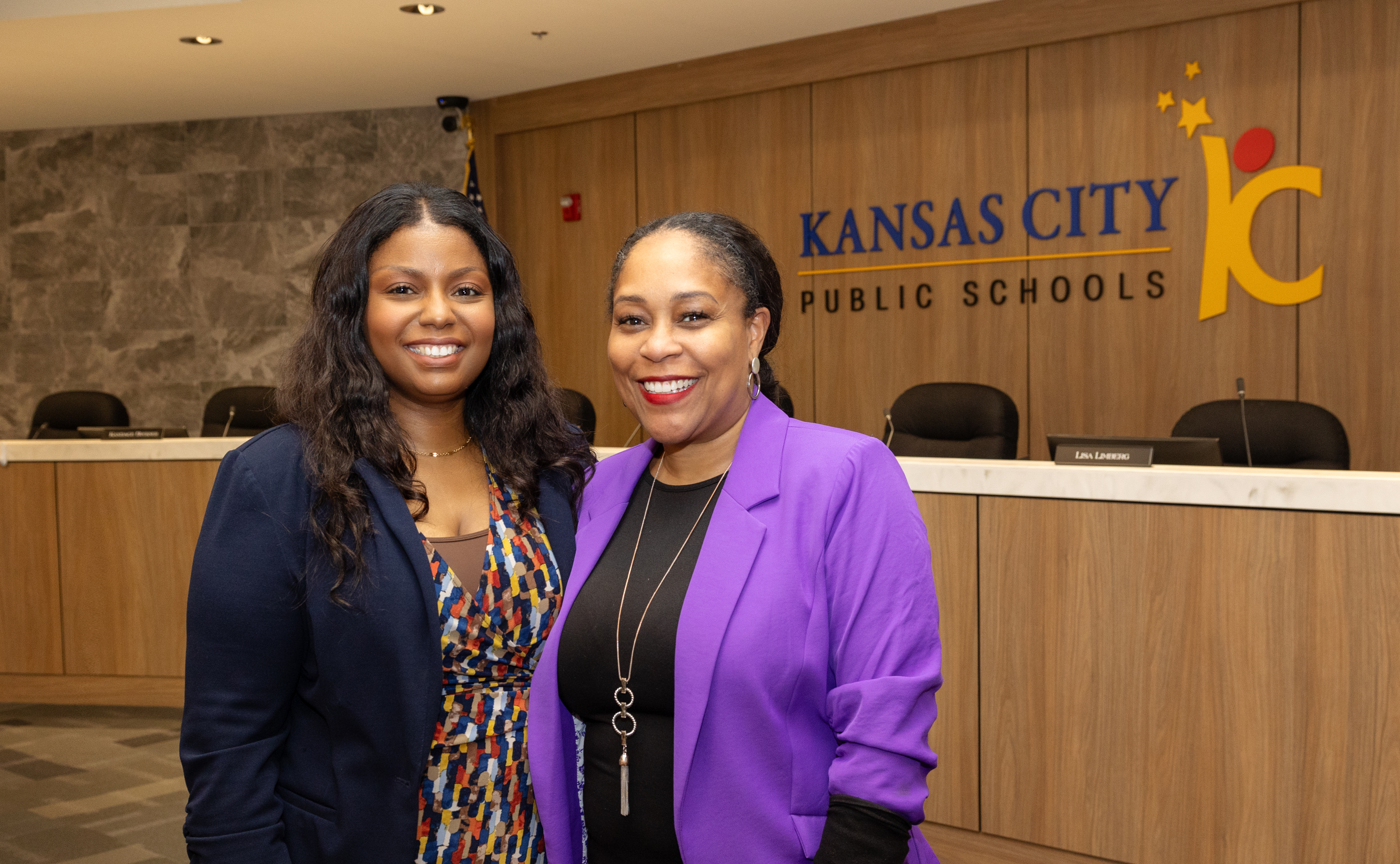 Two school district administrators smile at the camera 