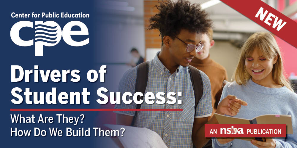 Two students looking at a book in a school cooridor