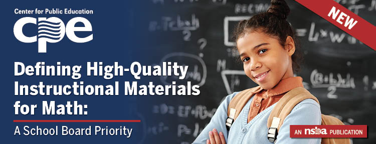 A student smiling in front of a blackboard