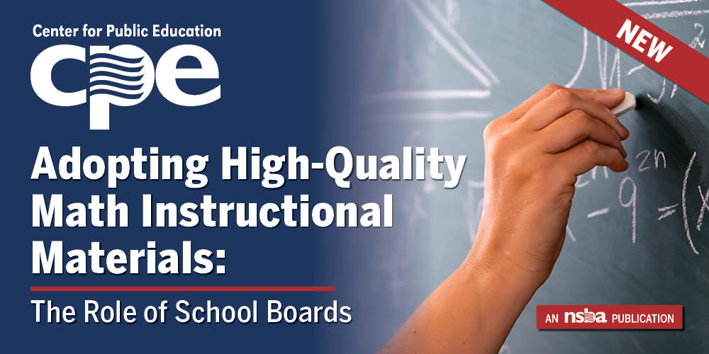 A hand holding a piece of chalk writing on a blackboard