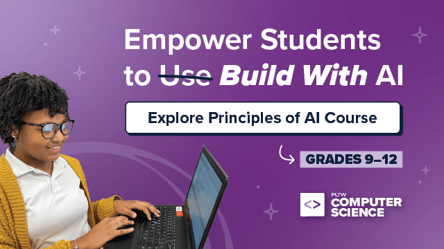 A student smiles while working on a laptop