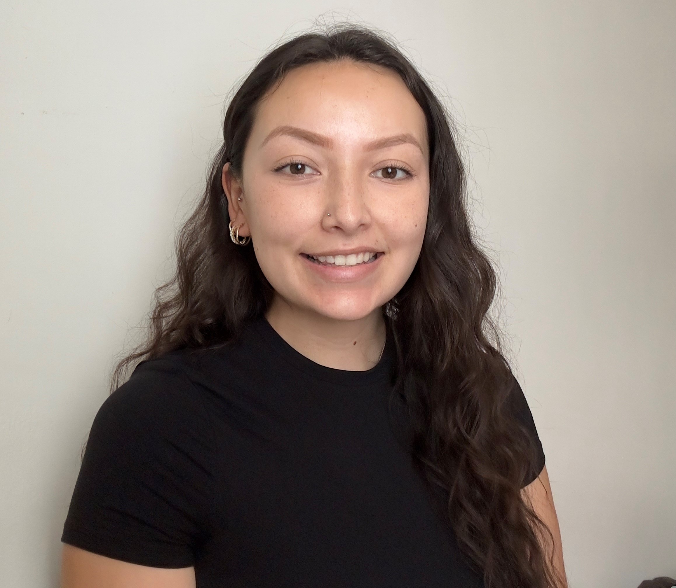 A person with long hair wearing a black shirtDescription automatically generated