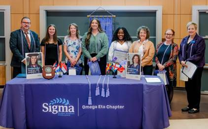 A group of women standing in front of a table with awards

AI-generated content may be incorrect.