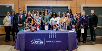 A group of women standing in front of a table with a table with a sign

AI-generated content may be incorrect.
