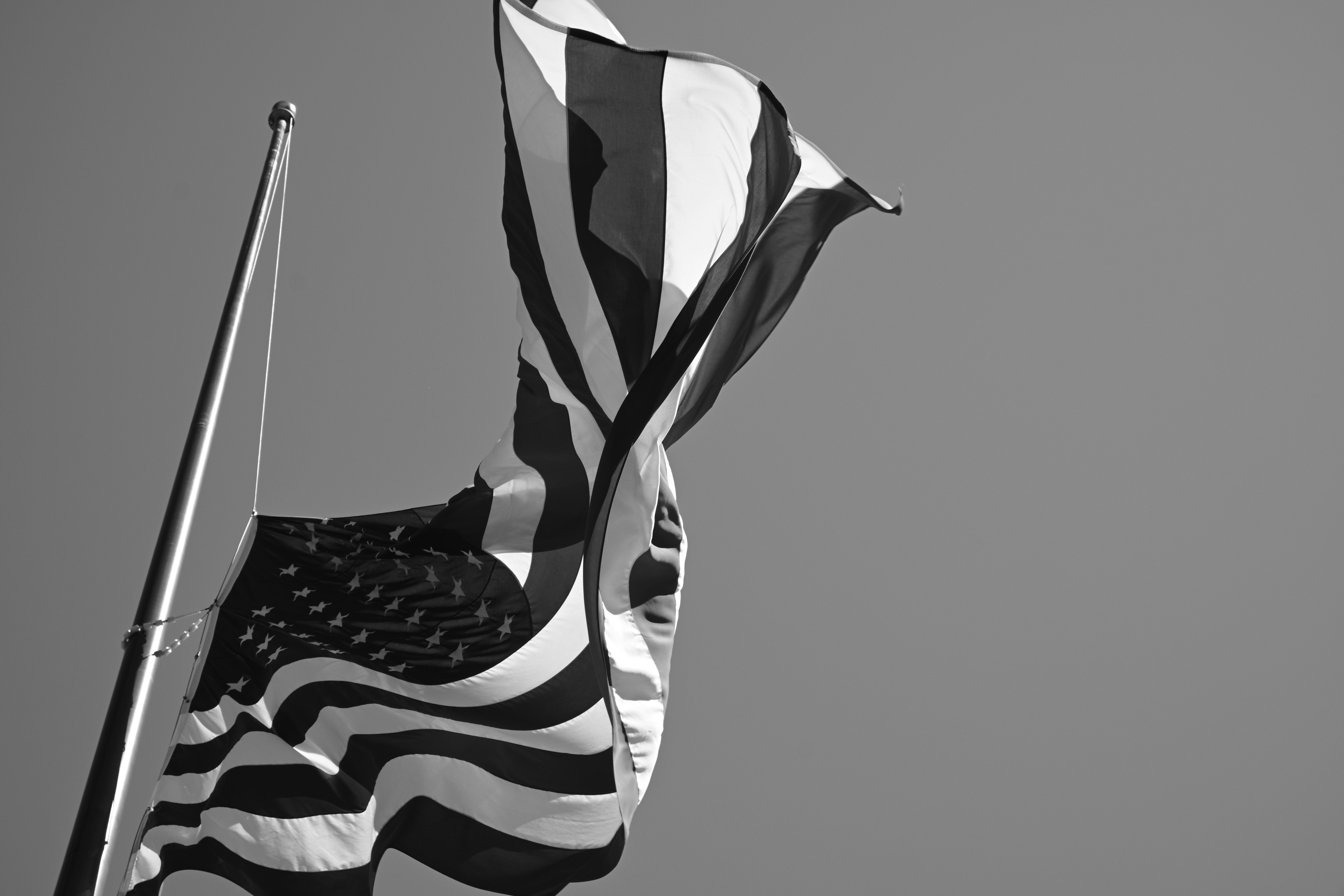 Black and white photo of the USA Flag flying on a flagpole