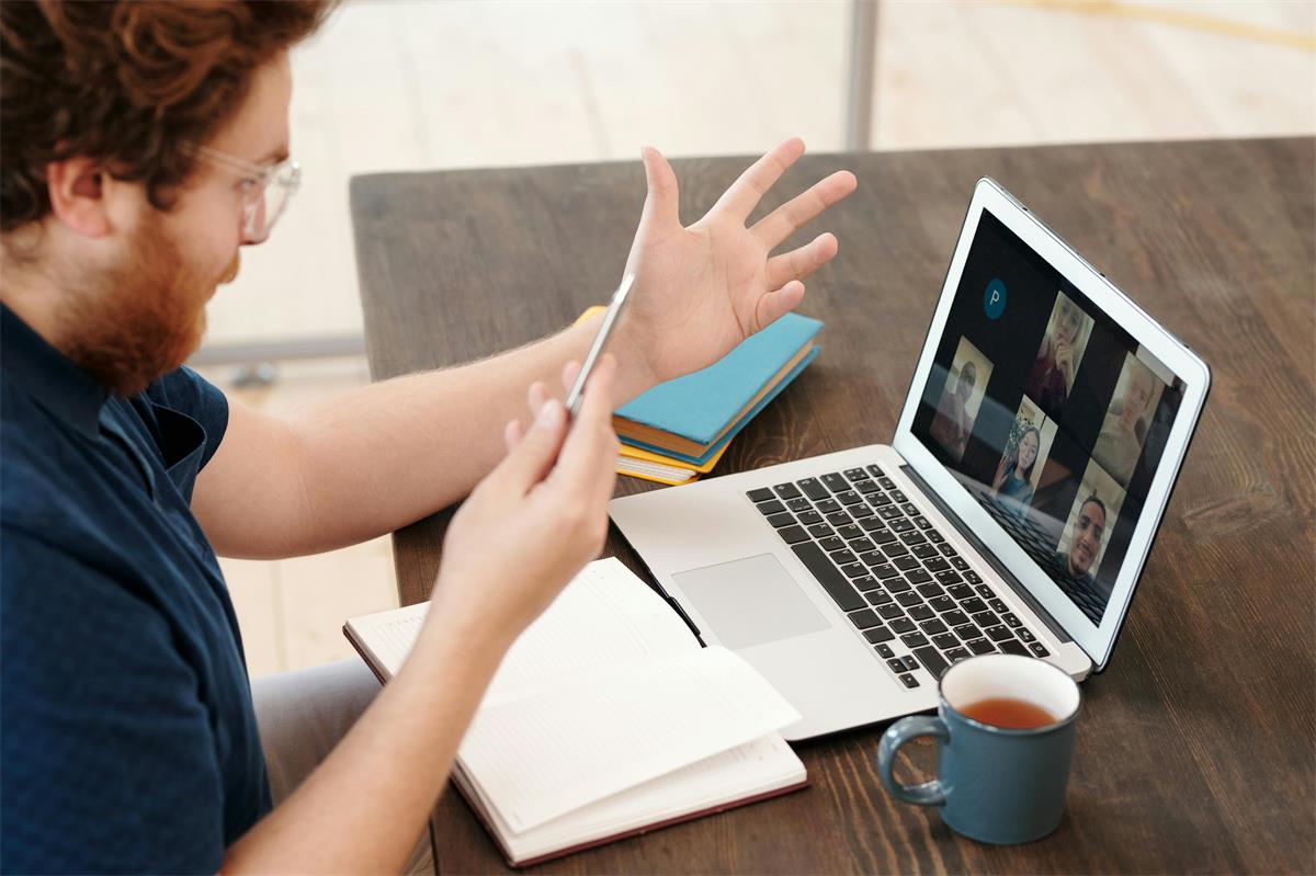 Man excitedly gestures while meeting on a laptop