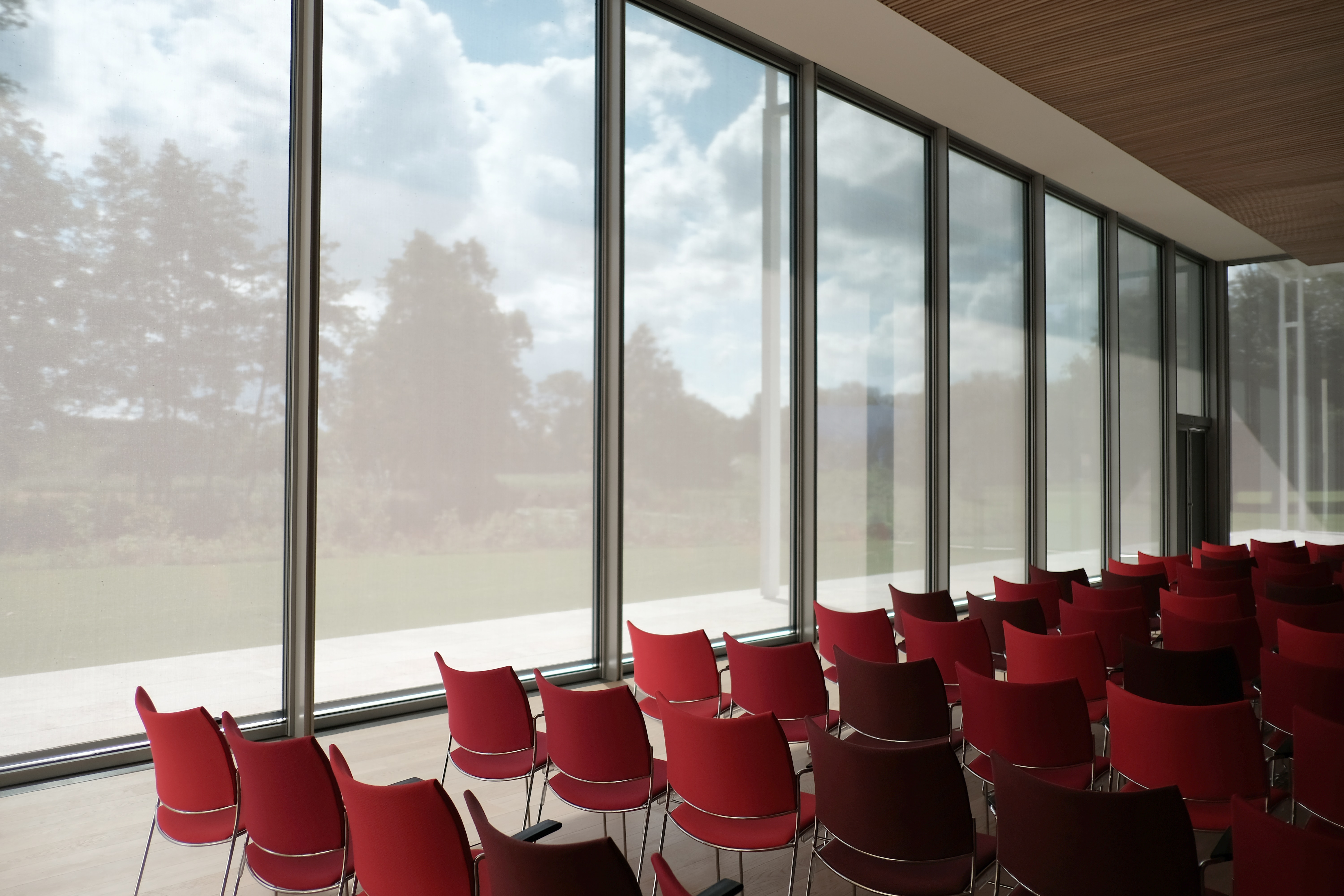 Empty red chairs facing one direction like in a classroom