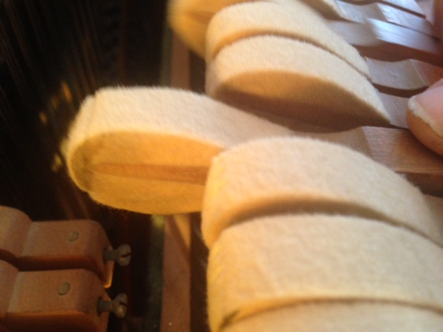 Felt glued to striking surface of flattened hammer