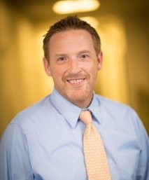 A person wearing a blue shirt and tie

Description automatically generated