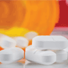 Tipped bottle with pills spilling out Pain killers