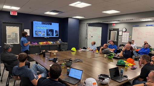 A group of people sitting around a table
AI-generated content may be incorrect.