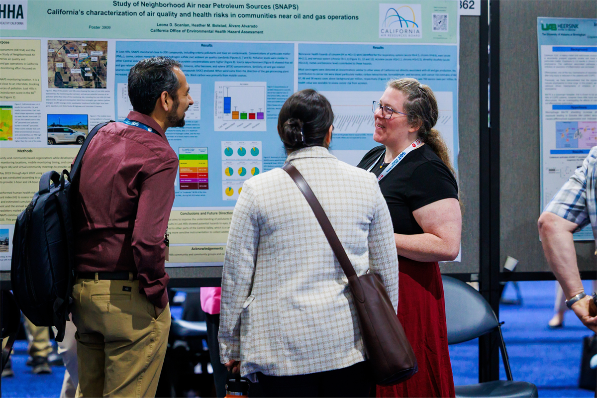 three people standing at a poster at 2026 SOT
