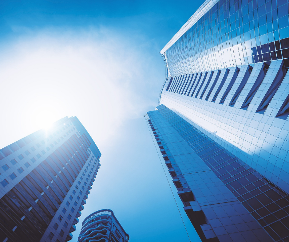 Space Coast Association of REALTORS® Commercial Investment Committee logo Picture of skyscrapers in the sun from the sidewalk's perspective