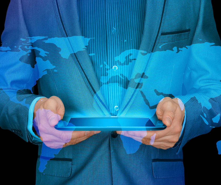 Space Coast Association of REALTORS® Global Committee logo Man in gray suit holding a tablet with graphics of a world atlas floating from it