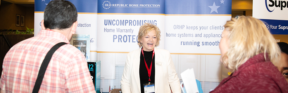 Sponsors at their booth during a business conference. Sponsors at their booth during a business conference.