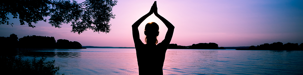 Silhouette woman practicing yoga posing Sunrise Yoga