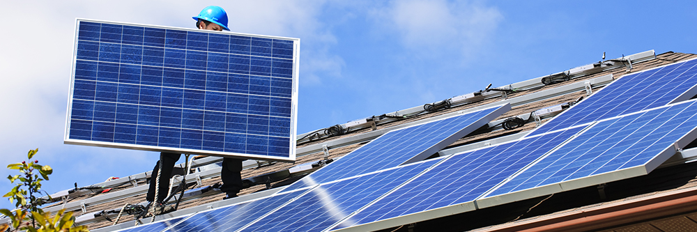 Missouri Home Energy Certification Man walking on roof holding a solar panel