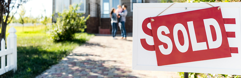 family moving into new house with sold sign