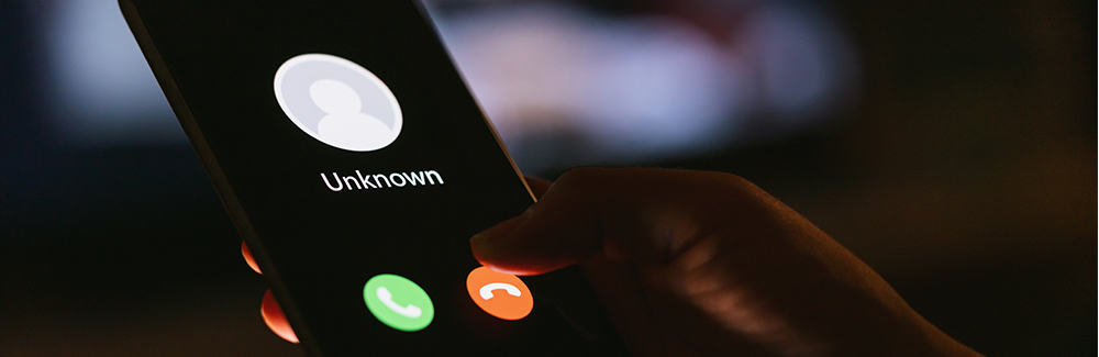 person holding a phone with an unknown caller on the screen