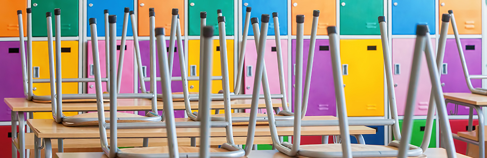 Empty Classroom with colorful lockers and raised chairs on the tables