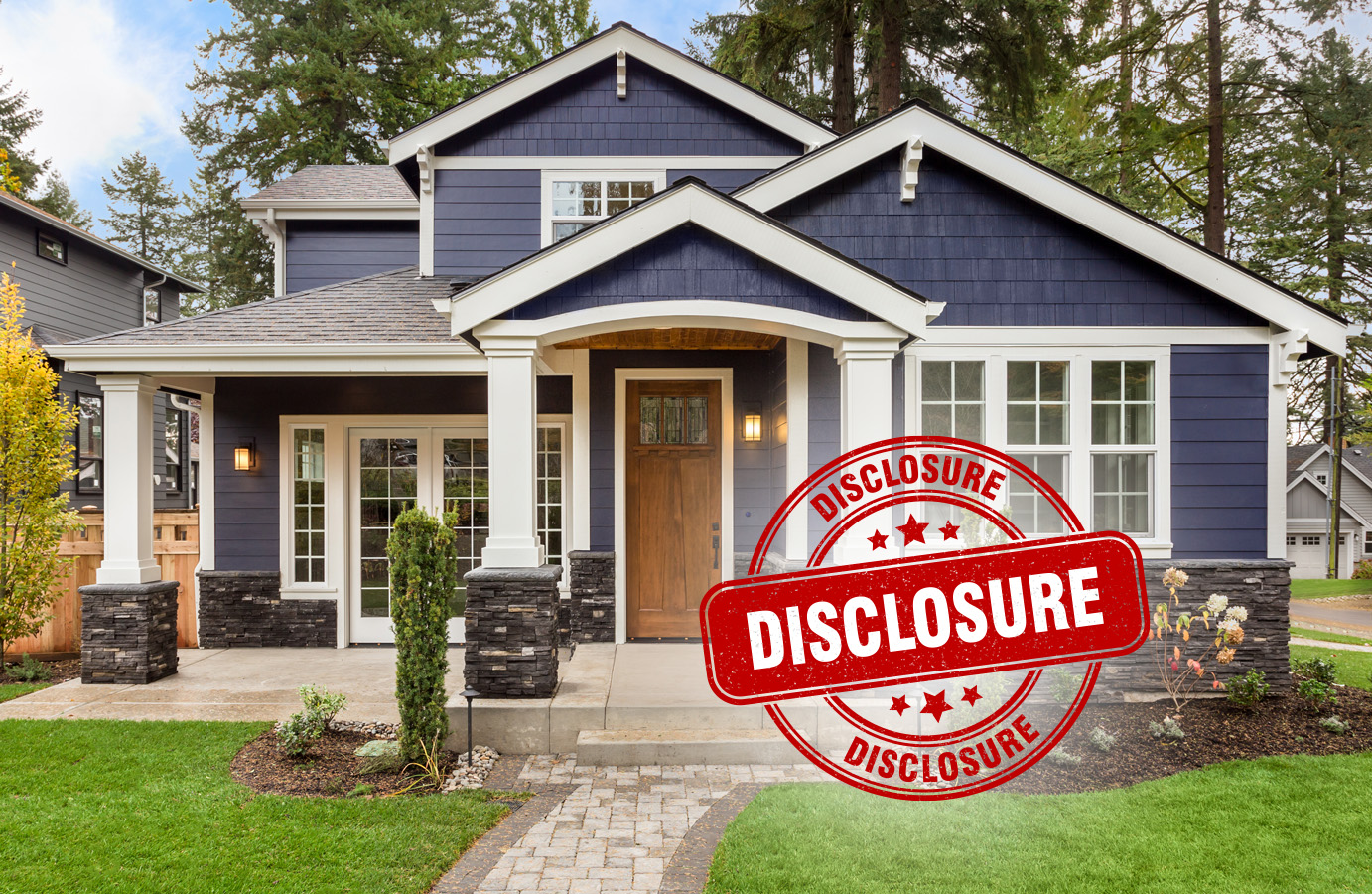 A blue home with a brown door and many white windows in front of pine trees. A round graphic on the home reads 
