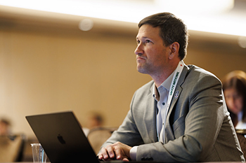 Member thinking in front of laptop