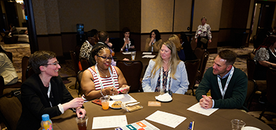Newcomers to the 2025 annual conference talking around a table